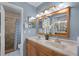 Bathroom showcasing double sinks, wood-framed mirror, and a walk-in shower with blue accents at 5815 England Ave, Orlando, FL 32808