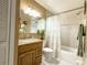 Well-lit bathroom features a shower over bath, floral curtain, and vanity sink at 5815 England Ave, Orlando, FL 32808