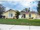 Charming single-Gathering home with a well-maintained lawn and landscaping, complemented by a classic yellow exterior at 5815 England Ave, Orlando, FL 32808