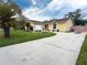 Inviting one-story home with a concrete driveway, attached garage, and meticulous landscaping at 5815 England Ave, Orlando, FL 32808