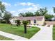 Inviting one-story home featuring a well-manicured lawn, mature trees, and a long driveway at 5815 England Ave, Orlando, FL 32808