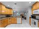 Kitchen with wood cabinets, granite counters, white appliances, and view into the living room at 5815 England Ave, Orlando, FL 32808