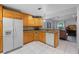 Bright kitchen with wooden cabinets, granite counters, and open concept to the living room at 5815 England Ave, Orlando, FL 32808