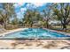 Community pool surrounded by lounge chairs and mature trees under a blue sky at 5815 England Ave, Orlando, FL 32808