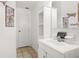 Well-lit bathroom featuring a white sink and vanity, with a mirror and decorative art at 5820 Indian Hill Rd, Orlando, FL 32808