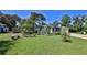 Inviting front yard with lush green grass, palm trees, and a quaint seating area at 60 Palmetto Dr, Ormond Beach, FL 32176