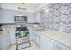 Charming kitchen with stainless steel appliances, modern backsplash and tile floors at 624 Cardinal St, Ocoee, FL 34761