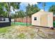 View of backyard with batting cage, storage shed, and pool deck at 679 N Endeavour Dr, Winter Springs, FL 32708