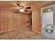 Bedroom with wood paneling and ceiling fan, opens to a bathroom at 679 N Endeavour Dr, Winter Springs, FL 32708