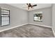 Neutral-toned bedroom with wood-look floors, bright windows, and minimalist decor at 679 N Endeavour Dr, Winter Springs, FL 32708