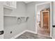 Functional laundry room with overhead cabinet and open shelving at 679 N Endeavour Dr, Winter Springs, FL 32708