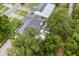 Aerial view of a home with a screened-in pool, mature trees, and a well-maintained lawn at 7011 Archwood Dr, Orlando, FL 32819