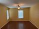 Bedroom with hardwood floors, a ceiling fan, and natural light from two windows at 7011 Archwood Dr, Orlando, FL 32819