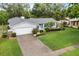 Charming home with lush landscaping, well-manicured lawn, and a spacious driveway at 7011 Archwood Dr, Orlando, FL 32819