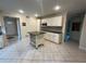 Well-lit kitchen with white cabinets, granite countertops, and a functional island at 7011 Archwood Dr, Orlando, FL 32819