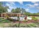 Landscaped backyard featuring an in-ground swimming pool, patio, and manicured garden beds at 7205 June Bug Ln, Orlando, FL 32818