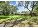 Spacious lawn with mature trees surrounding a well-maintained brick home, providing a serene setting at 7205 June Bug Ln, Orlando, FL 32818