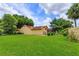 Spacious backyard with green lawn, landscaping and screened-in patio and pool at 8143 Terragona Ct, Orlando, FL 32836