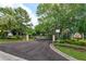 Gated entrance to Granada Villas featuring mature trees and manicured landscaping at 8143 Terragona Ct, Orlando, FL 32836