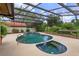 Screened-in pool with an attached spa and lush landscaping at 8143 Terragona Ct, Orlando, FL 32836
