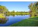 Breathtaking backyard view of tranquil lake, mature trees, and lush green grass, perfect for relaxation at 932 S Lake Sterling Ct, Casselberry, FL 32707
