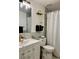 Well-lit bathroom has marble walls, modern fixtures, and a shower with a curtain at 932 S Lake Sterling Ct, Casselberry, FL 32707