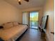 Comfortable bedroom featuring a bed, sliding glass door, and views of the surrounding landscape at 932 S Lake Sterling Ct, Casselberry, FL 32707