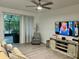 Bright living room with hardwood floors, a flatscreen television, sliding glass doors, and modern ceiling fan at 932 S Lake Sterling Ct, Casselberry, FL 32707