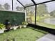 Relax on this screened patio with artificial turf, plants, and beautiful lake views, creating a serene atmosphere at 932 S Lake Sterling Ct, Casselberry, FL 32707