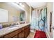 Bathroom featuring a double sink vanity with granite countertop and a shower with decorative curtain at 969 Springs Landing Dr, Deltona, FL 32725