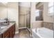 Bathroom features a double vanity, soaking tub, and walk-in shower with a glass door at 969 Springs Landing Dr, Deltona, FL 32725