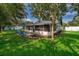 A lovely backyard with green grass, patio, tropical plants and trees with outdoor seating at 1000 Chesterfield Cir, Winter Springs, FL 32708