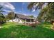 Spacious backyard featuring a well-maintained lawn, mature trees, and a brick patio with comfortable seating at 1000 Chesterfield Cir, Winter Springs, FL 32708