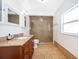 Bright bathroom with a granite countertop vanity, glass-enclosed shower, and neutral color palette at 1000 Chesterfield Cir, Winter Springs, FL 32708