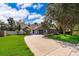 Inviting home showcasing lush landscaping, a spacious driveway, and a classic brick and siding facade at 1000 Chesterfield Cir, Winter Springs, FL 32708