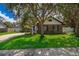 Attractive home with a brick facade, complemented by mature trees and a green lawn at 1000 Chesterfield Cir, Winter Springs, FL 32708