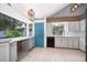 Bright kitchen showcasing white cabinets, a view to the backyard, and a blue accent door at 1000 Chesterfield Cir, Winter Springs, FL 32708