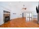 Living room showcasing a fireplace and hardwood floors, with access to the kitchen at 1000 Chesterfield Cir, Winter Springs, FL 32708