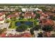 A scenic aerial view of townhomes surrounding a lush green space and pond at 12106 Poppy Field Ln # 107, Orlando, FL 32837