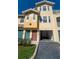 Charming yellow townhouse with garage, well-manicured landscaping, and inviting front entrance at 12106 Poppy Field Ln # 107, Orlando, FL 32837