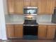 A bright kitchen with wooden cabinets, stainless steel appliances, and light countertops at 12106 Poppy Field Ln # 107, Orlando, FL 32837