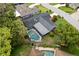 An aerial view displays the screened in pool with mature trees and tropical landscaping at 126 Duncan Trl, Longwood, FL 32779