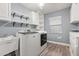 Well-organized laundry room with washer, dryer, shelving, and built-in sink at 126 Duncan Trl, Longwood, FL 32779