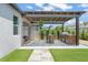 Backyard featuring a pergola-covered outdoor kitchen, and a path to an outdoor living area at 13227 Spring Grove Way, Winter Garden, FL 34787