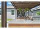 Backyard with an outdoor kitchen and living space under a pergola, next to hot tub and lawn at 13227 Spring Grove Way, Winter Garden, FL 34787
