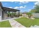 Landscaped backyard featuring a pergola with bar, patio, artificial turf, and walkway at 13227 Spring Grove Way, Winter Garden, FL 34787