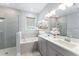 Stylish bathroom featuring double vanity, glass shower, soaking tub, and well-lit design at 13227 Spring Grove Way, Winter Garden, FL 34787