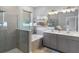 Modern bathroom featuring double vanity, glass-enclosed shower, soaking tub, and neutral tile at 13227 Spring Grove Way, Winter Garden, FL 34787