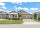Charming home with covered porch, brick driveway, and manicured landscaping at 13227 Spring Grove Way, Winter Garden, FL 34787