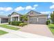 Charming home with covered porch, brick driveway, and manicured landscaping at 13227 Spring Grove Way, Winter Garden, FL 34787
